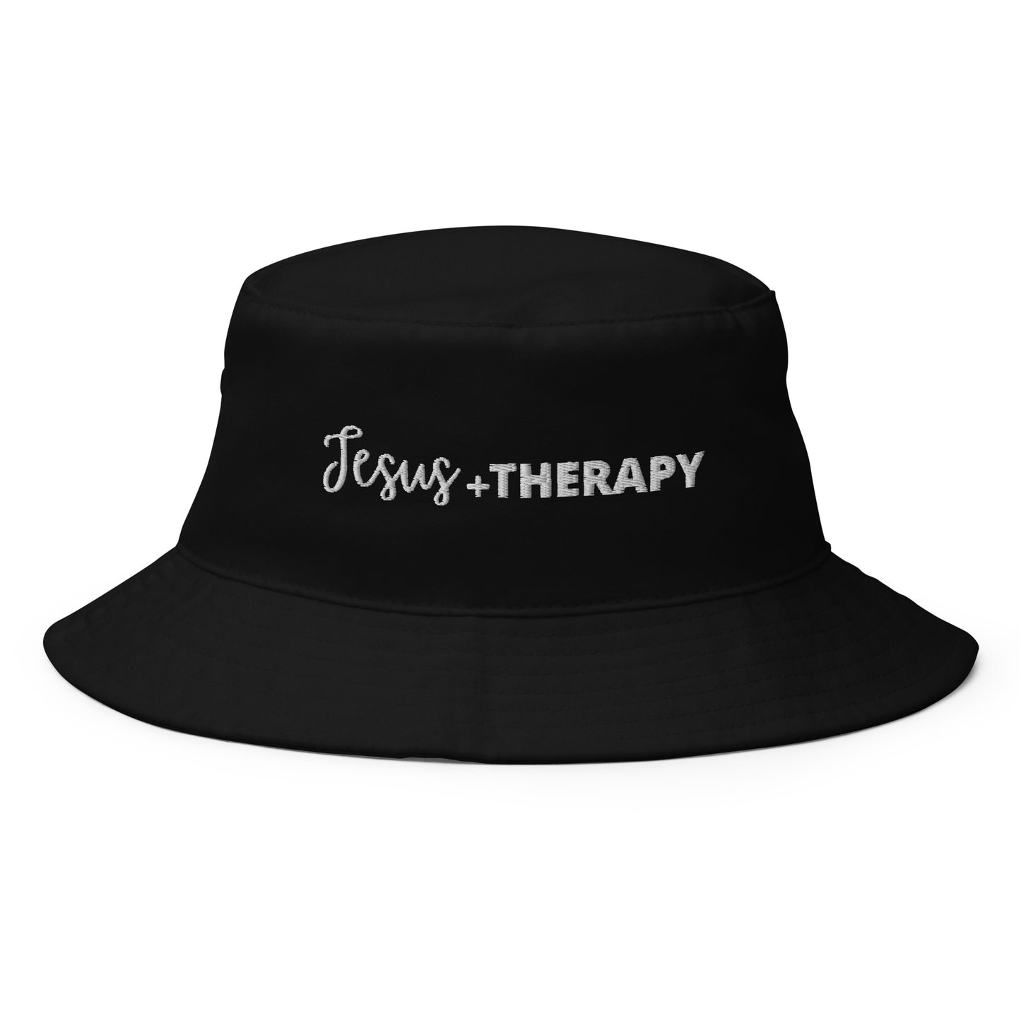 A black bucket hat featuring the text "Jesus + Therapy" in elegant white font.