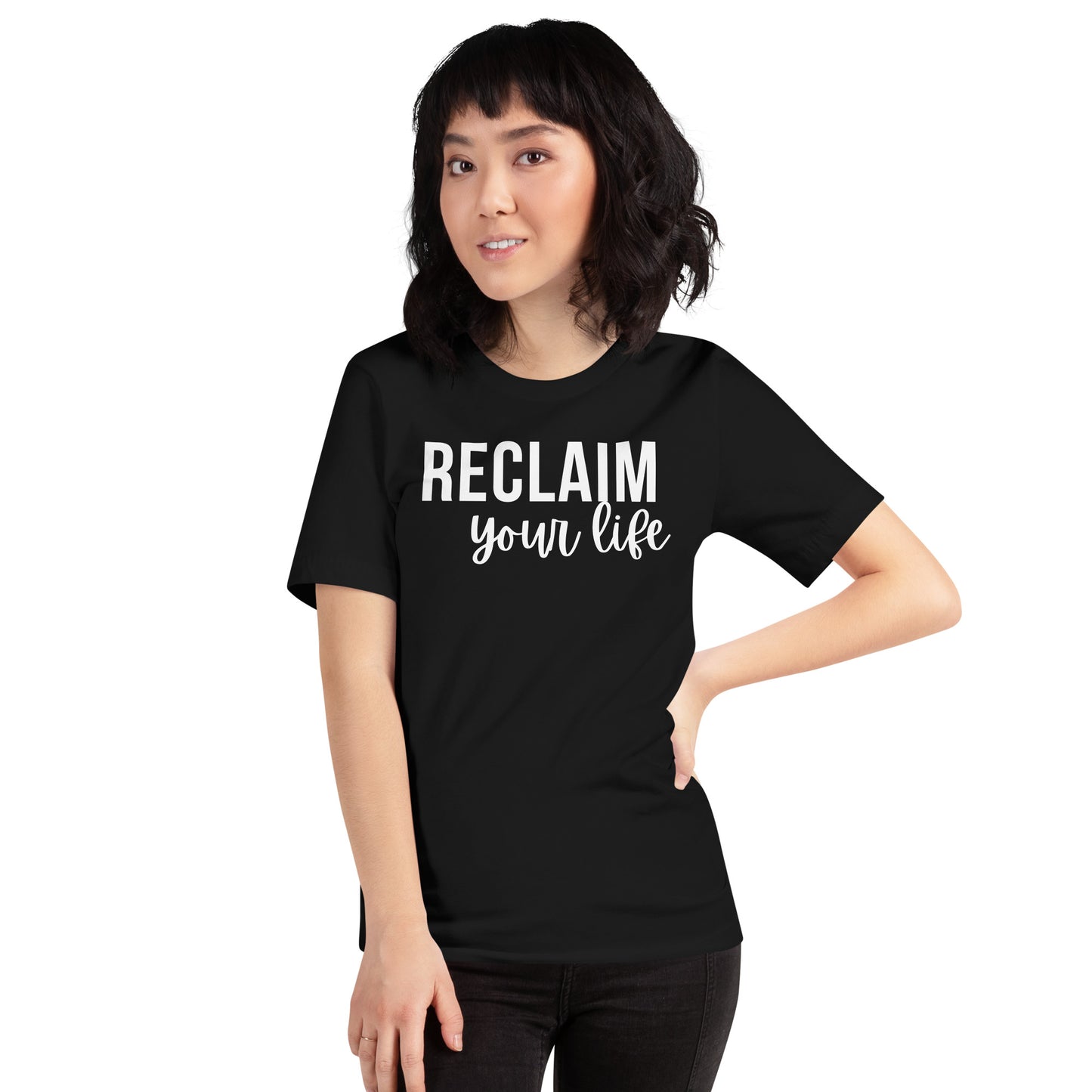 A woman wearing a black unisex t-shirt with "Reclaim Your Life" text in clean, bold white font.